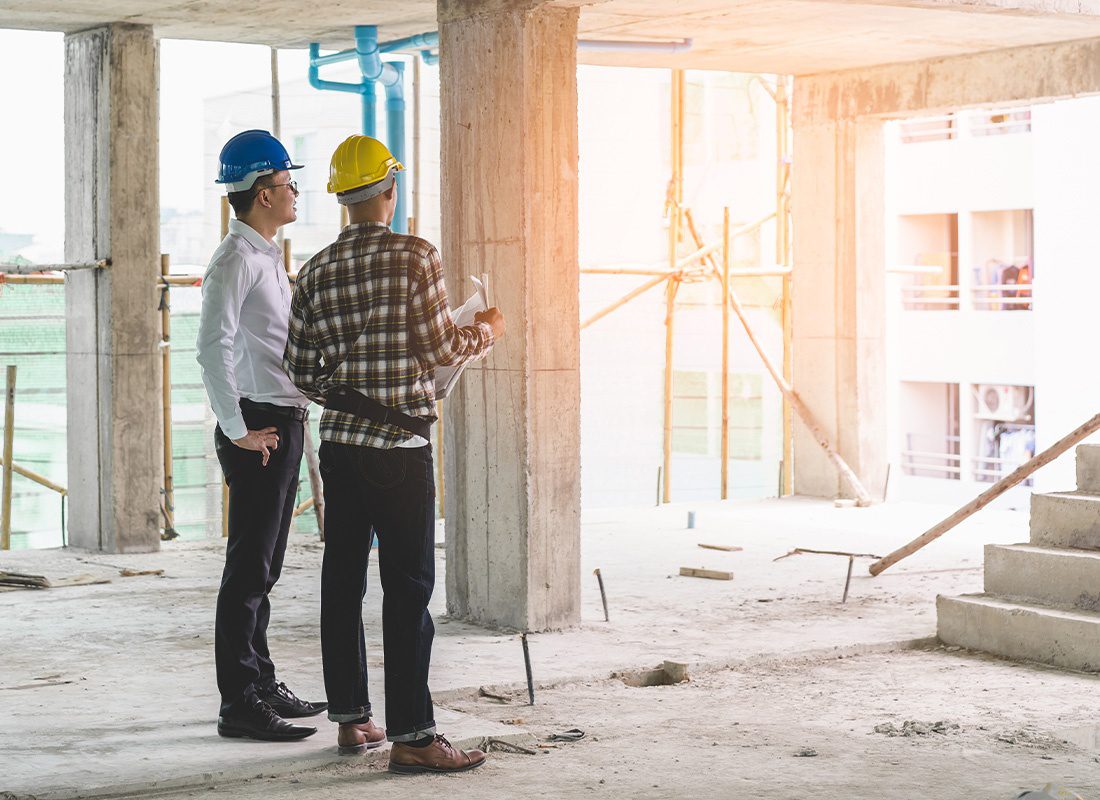 Insurance Solutions - Contractor and Engineer Inspecting Material in a Large Construction Building